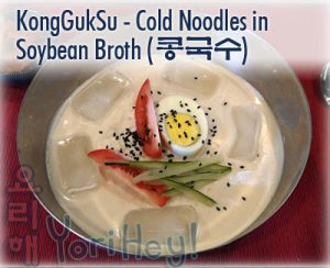 KongGukSu (콩국수) - Korean Cold Noodles in Soy Bean Broth - Dish served with cucumber, tomato and sesame seeds for garnish with ice cubes in broth