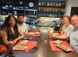 Sushi Class - Four attendees pose with their sushi plate creations